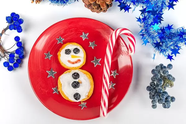 Snowman made of pancakes with striped lollipop stick and stars
