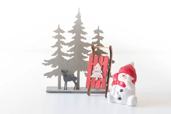 Snowman with sleighs in the forest