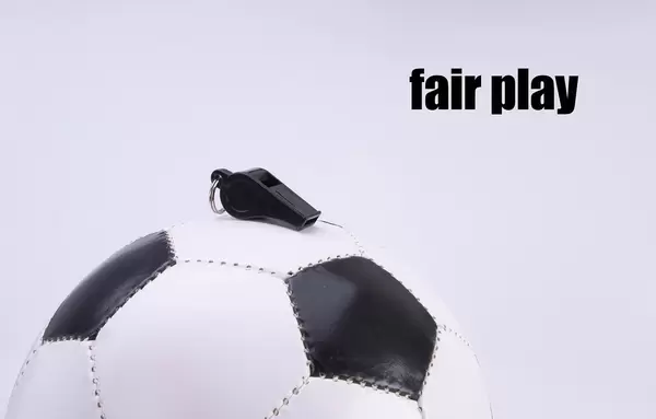 Soccer ball and sports whistle with Fair play text on white background