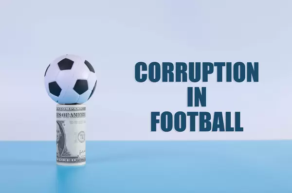Soccer ball on a money roll with Corruption in Football text
