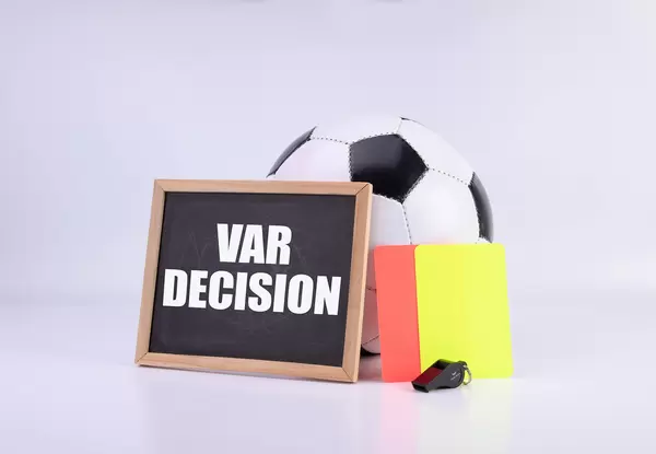 Soccer ball, referee cards and chalkboard witt VAR decision text