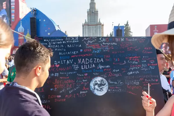 Soccer fans writing messages on black board at fan fest