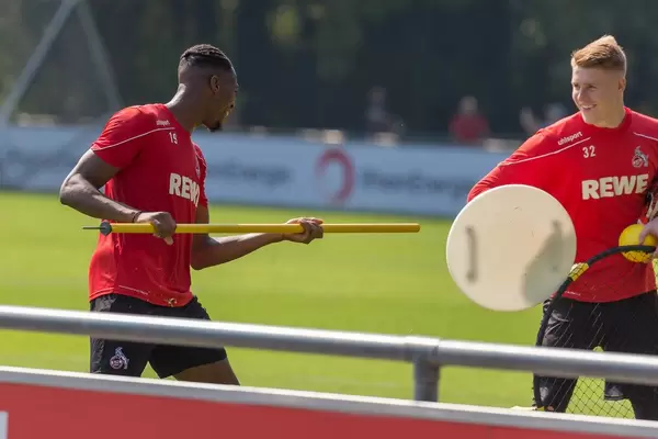 Soccer player Kingsley Ehizibue and goalkeeper Julian Krahl having fun after football training on the pitch in Cologne
