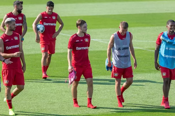 Soccer player leaving the field and walking in socks while carrying their sports shoes, after practice session