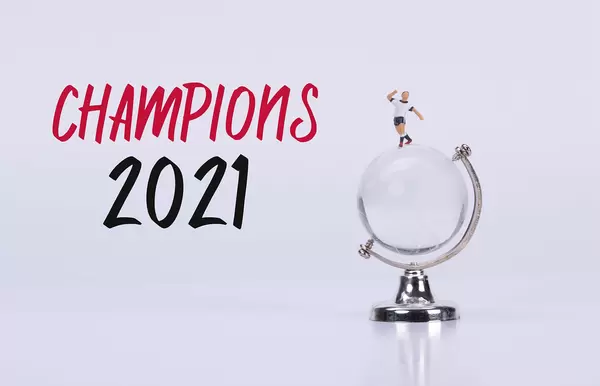 Soccer player standing on a glass globe with Champions 2021 text