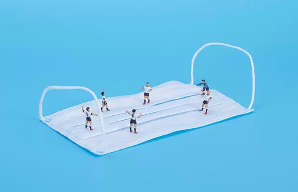 Soccer players playing football on medical face mask