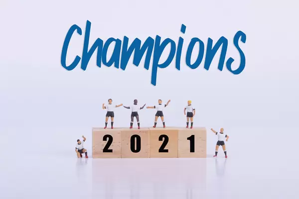 Soccer players standing on wooden cubes with 2021 text and Champions text