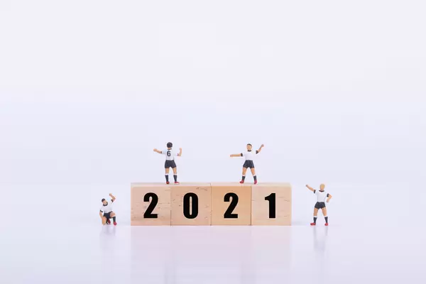 Soccer players standing on wooden cubes with 2021 text