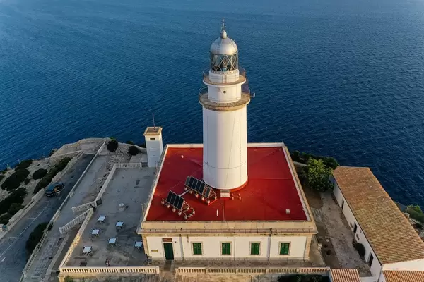 Solar panels on the red roof of the lighthouse at Cap de Formentor, Mallorca, seen against the blue sea