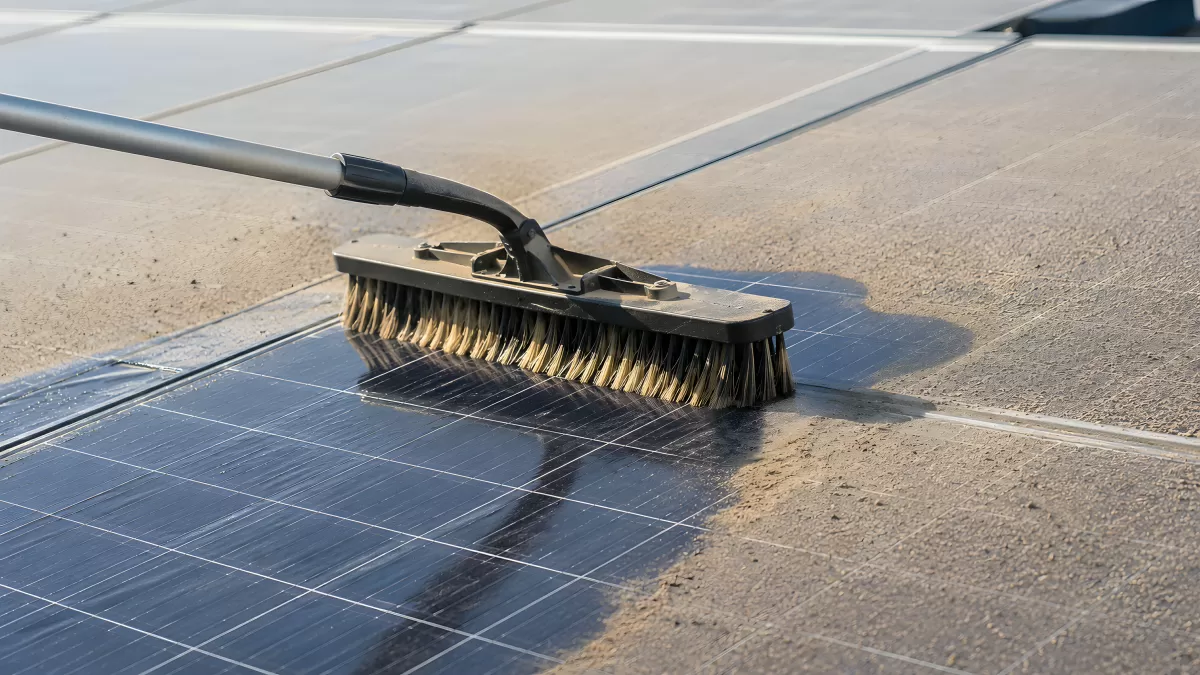 Solarmodul wird mit Bürste von Staub gereinigt