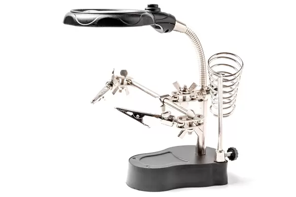 Soldering stand with helping clamps and magnifying glass on white background