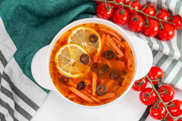 Solyanka russian soup with meat, sausage and olives, top view