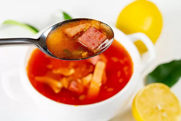 Solyanka with smoked chicken, veal and ham, close up in spoon (Flip 2019)