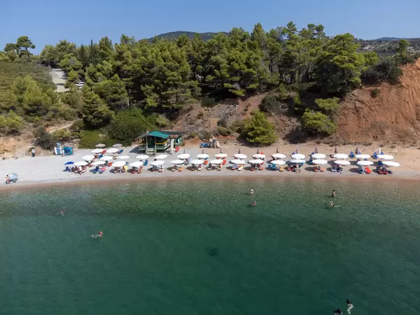 Sommerurlaub 2021 auf Alonnisos, Griechenland. Der Strand von Kokkinokastro mit weißen Sonnenschirmen