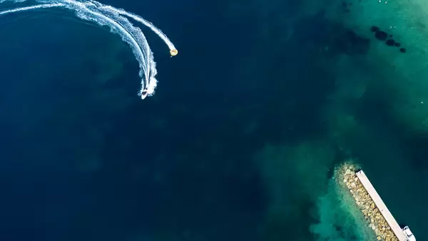 Sommerurlaub 2021 in Griechenland. Motorboot schleppt Aquadonut. Aufnahme von oben