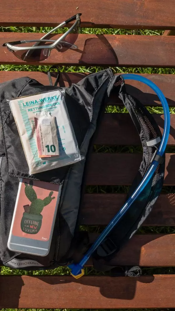 Sonnenbrille, Camelbak Trinkrucksack, Rettungsdecke, Handy und Bargeld