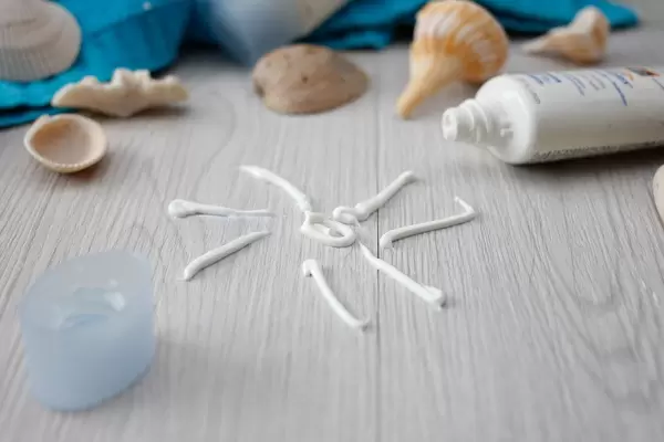 Sonnencreme und Muscheln auf dem Tisch