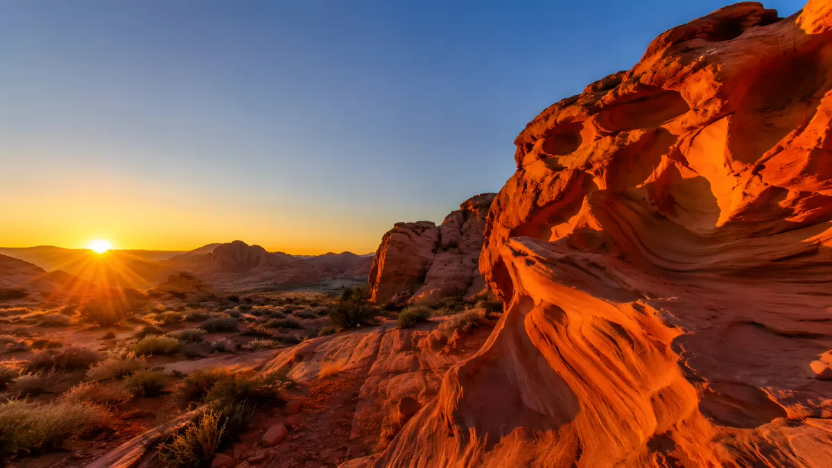 Sonnenuntergang über roter Felslandschaft in der Wüste