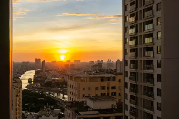 Sonnenuntergang zur Goldenen Stunde mit Ausblick auf Saigon River, Apartment Gebäude und Stau auf der Nguyen Van Cu Brücke in Ho Chi Minh Stadt, Vietnam