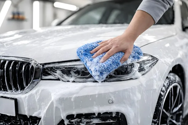 Sorgfältige Autoaufbereitung mit Mikrofasertuch