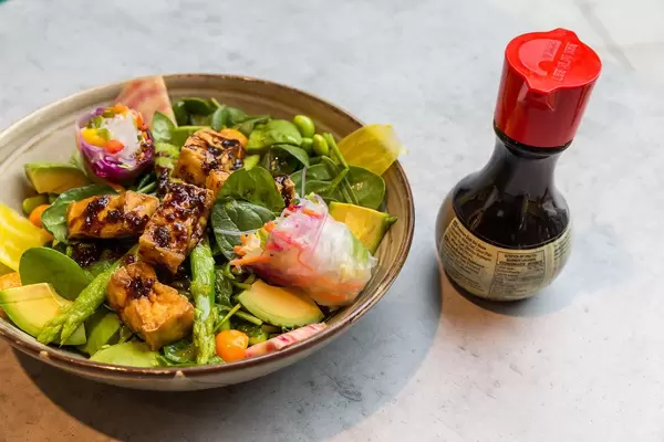 Soul Made: Veganisches Gericht des coa Wok & Bowl Restaurants im Köln mit Tofu, Babyspinat, Spargel, Bete, Avocado, Himbeer-Miso-Dressing und Chili Sauce