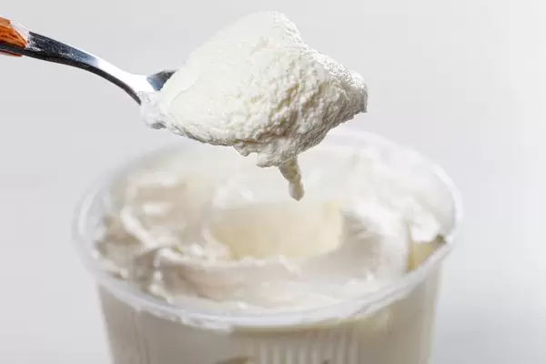 Sour cream in spoon and in plastic packaging (Flip 2019)