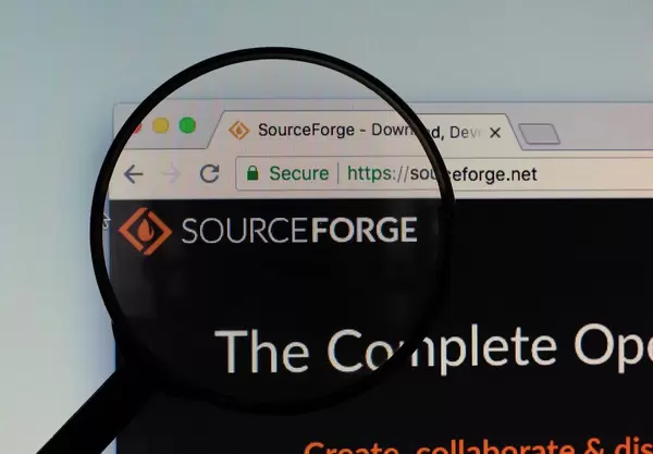 SourceForge-Logo am PC-Monitor, durch eine Lupe fotografiert