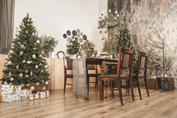 Spacious decorated living room with christmas trees and dining table