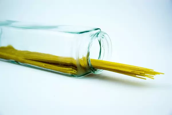 Spaghetti-Nudeln in eines Glas auf weißem Hintergrund