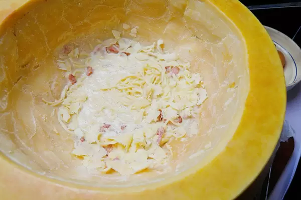 Spaghetti with bacon in parmesan cheese wheel ready to be served. Italian cuisine (Flip 2019)