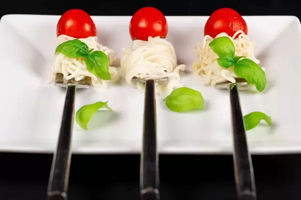 Spaghetti with basil and cherry tomatoes on forks