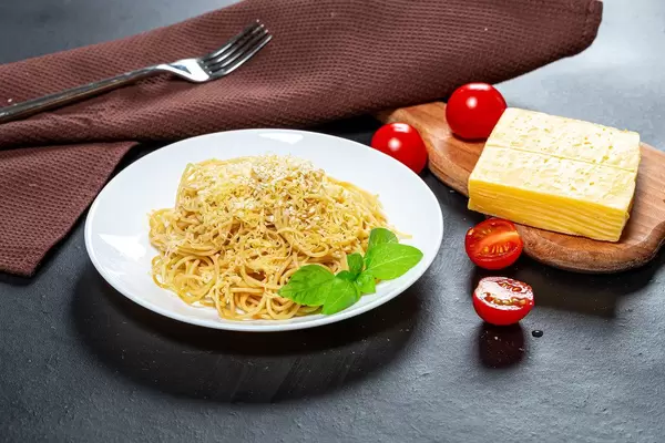Spaghetti with cheese and sesame seeds on a black background with tomatoes (Flip 2019)