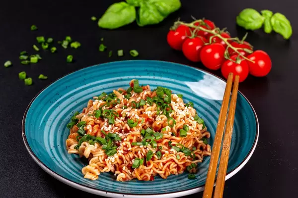 Spaghetti with tomato sauce, sesame seeds and chopsticks