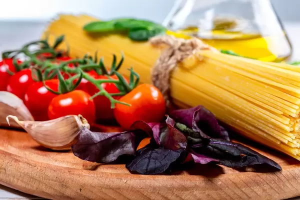 Spaghetti with tomatoes, basil, garlic and olive oil on board (Flip 2019)