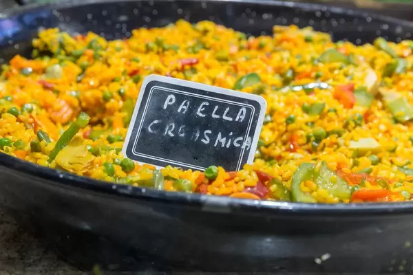 Spanisches Nationalgericht und Reispfanne "Paella" mit frischem Gemüse in einer Pfanne in der Mercat de la Boqueria in Barcelona