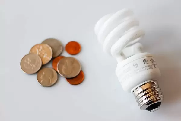 Sparsame Glühbirne neben Kleingeld