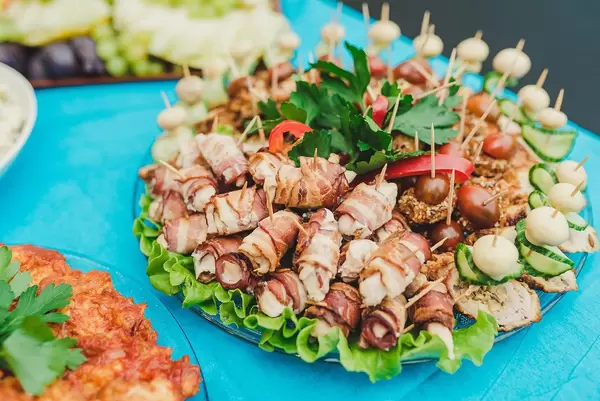 Speckröllchen, Salat und Tomaten auf bedecktem Tisch