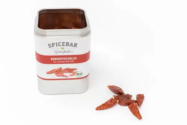 Spice can by  Spicebars - Gewürzküche with red and white colors, contains dried Birdseye chili peppers, for spicing up dishes, on a white background