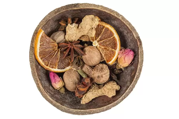 Spices for mulled wine in a wooden bowl, top view