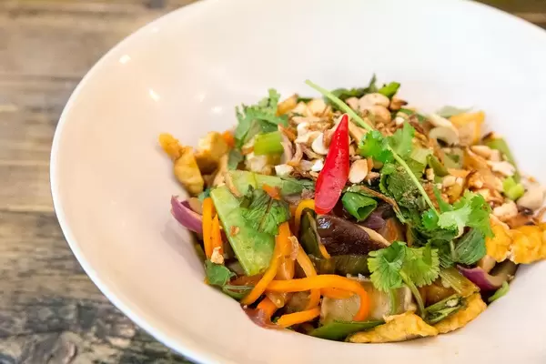 Spicy vegan tofu meal with onions, pak choi, peanuts and mushrooms in close-up served in Chum Chay restaurant in Cologne