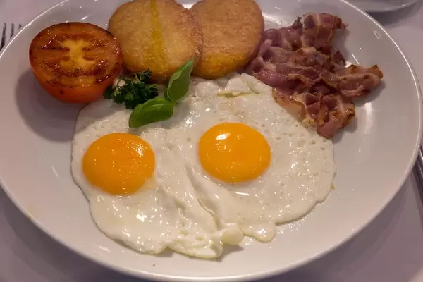 Spiegelei mit Speck auf einem weißen Teller