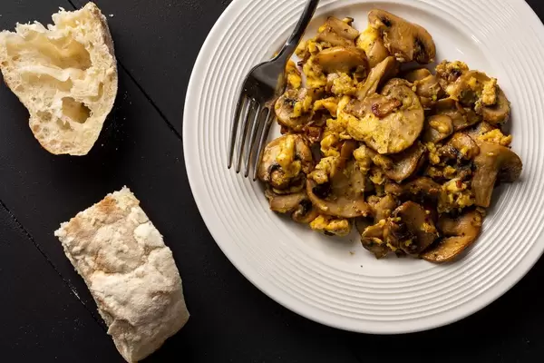 Spiegeleier und Pilze und Brot auf dem Tisch