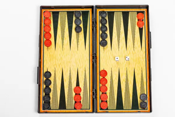 Spielbrett zum Backgammon spielen mit Figuren und Würfeln auf weißem Hintergrund. Ansicht von oben
