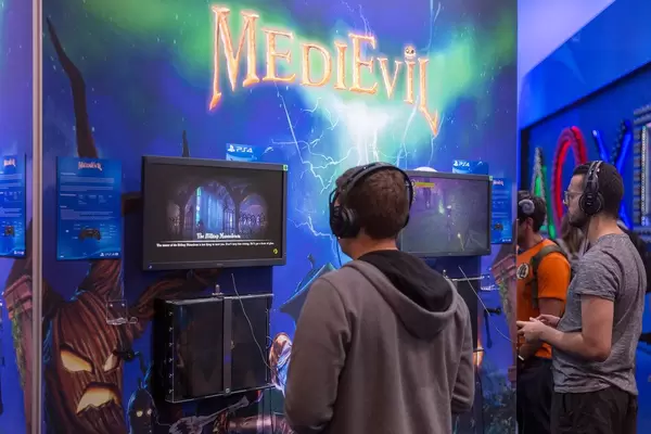 Spielemesse-Besucher mit Kopfhörer, spielen MedieEvil auf der PS4