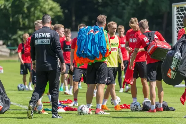 Spieler packen Sportbekleidung und Fußbälle aus
