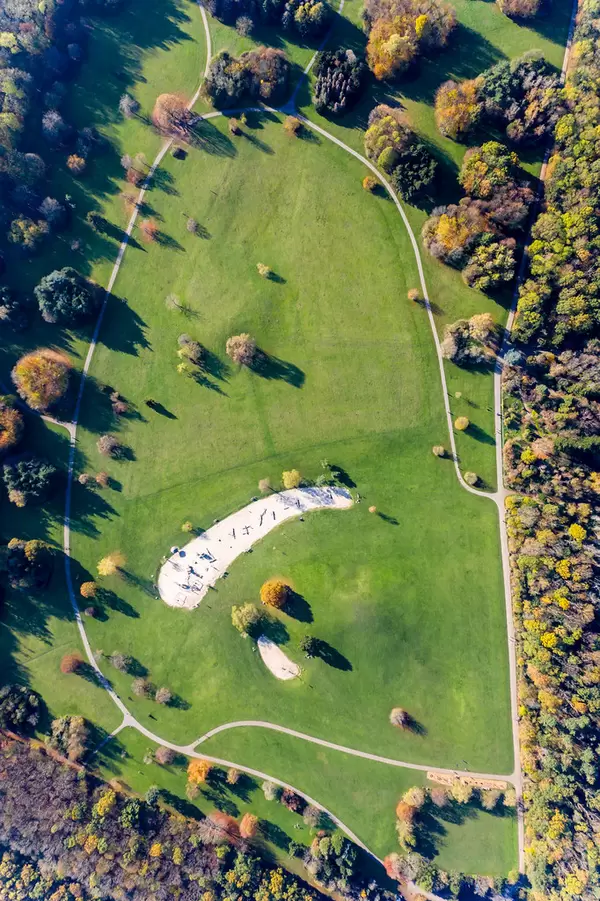 Spielplatz mit großer Grünfläche und Wegen im Forstbotanischen Garten und Friedenswald in Köln, Deutschland