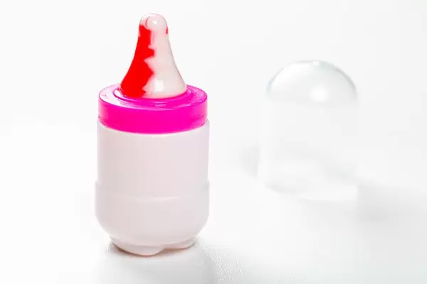 Spielzeug Baby Trinkflasche mit Nippel auf weißem Hintergrund