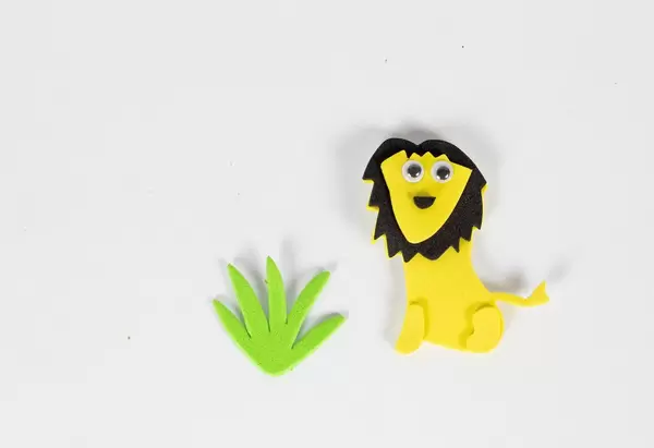 Spielzeug-Löwe mit Gras