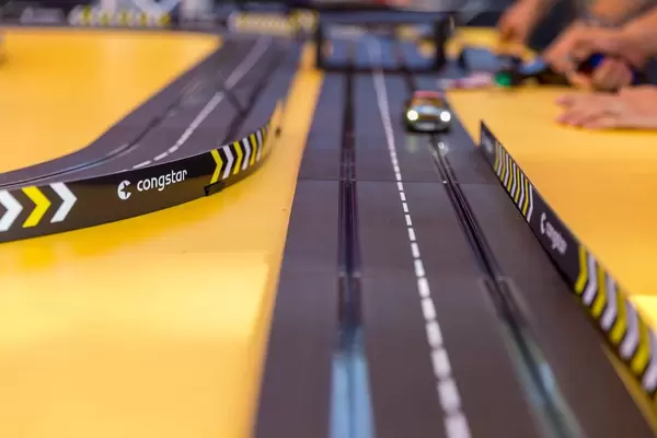 Spielzeugauto mit Beleuchtung fährt auf der Congstar Carrera-Bahn