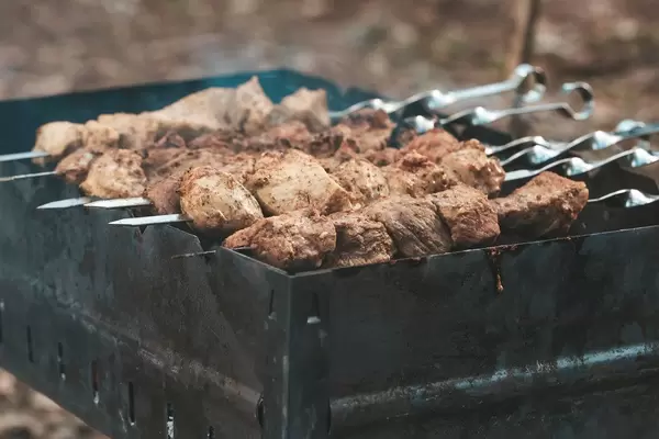 Spieße mit Schaschlik auf dem Grill im Wald